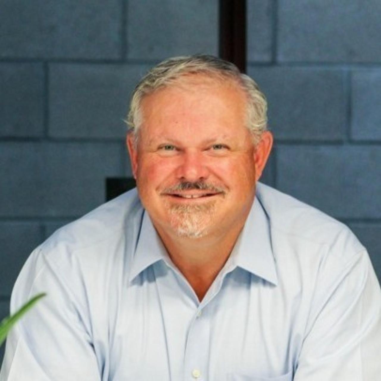 Image of Robin looking into camera wearing light blue collared shirt.