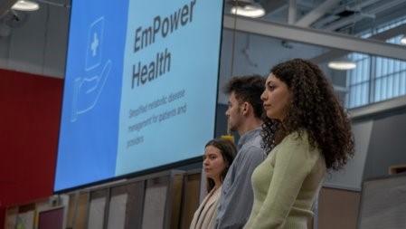 Side image of three empower health team members with powerpoint screen