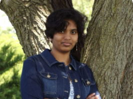 woman standing next to tree in denim jacket