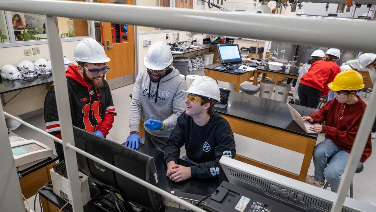 Group of students with hard hats in workshop