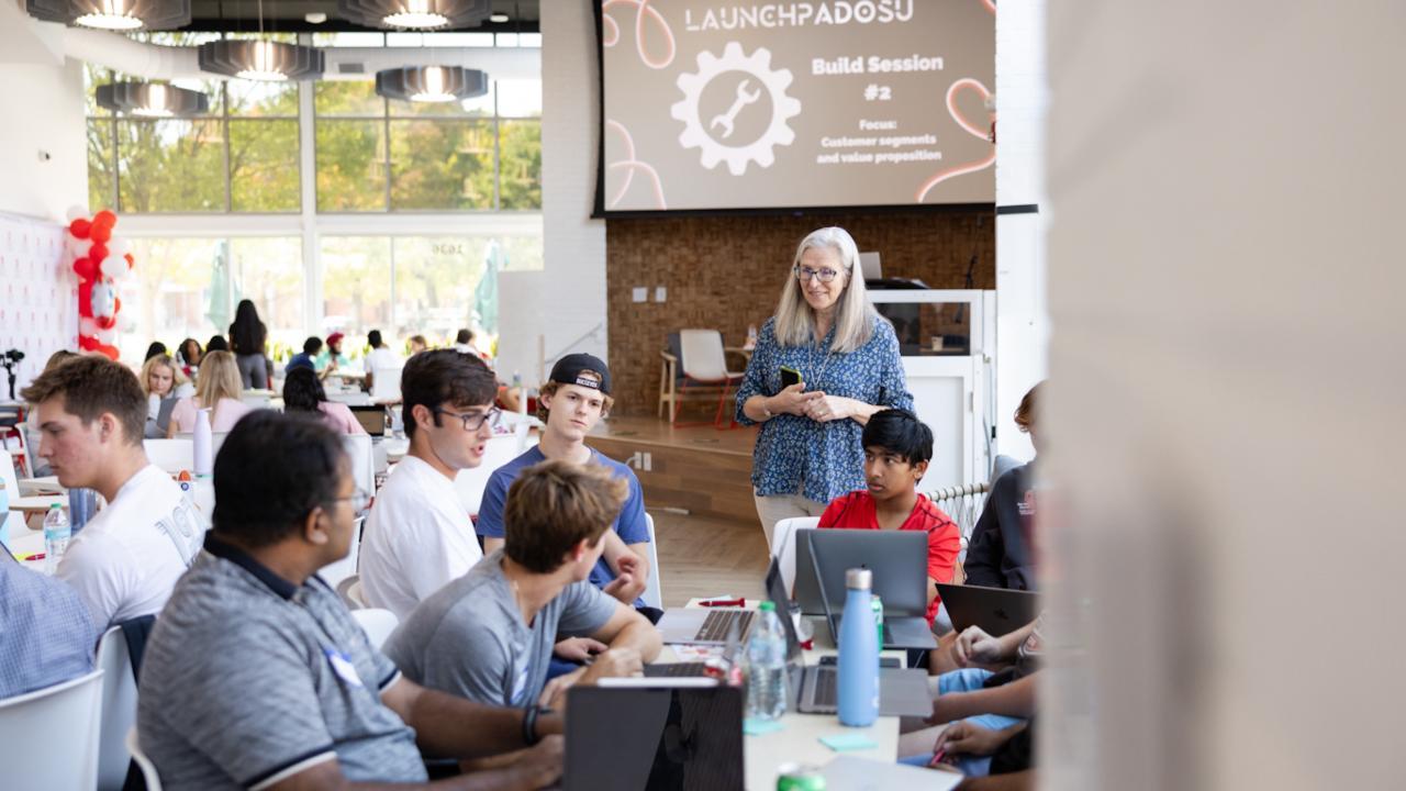 Woman speaking to a group of students. 